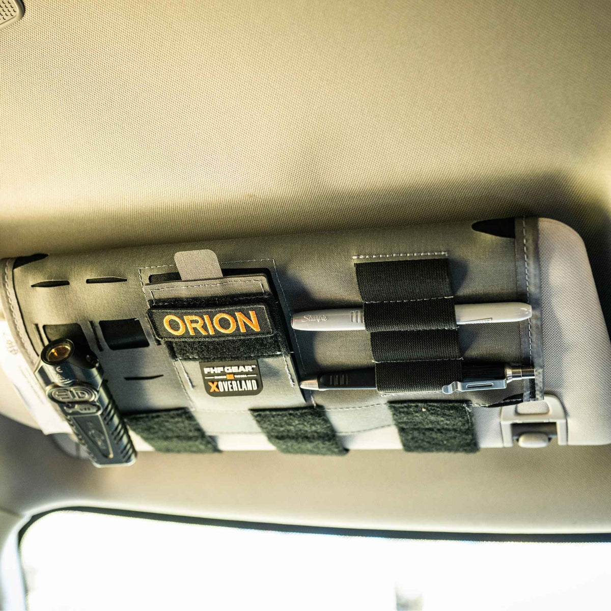 Gray car visor organizer installed and showing the accessories properly mounted.