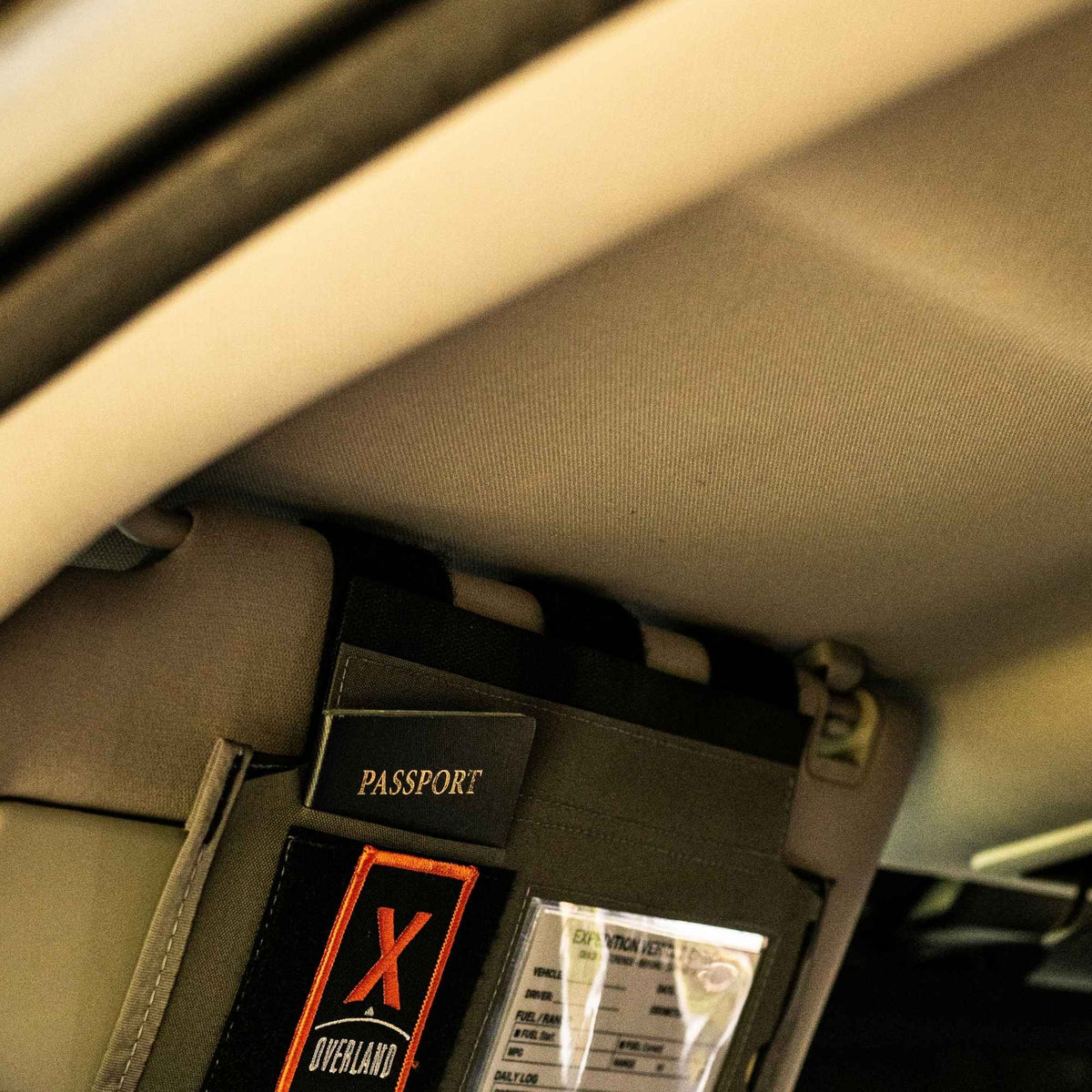 Gray car visor organizer properly mounted with a hook and loop system attached to the visor.