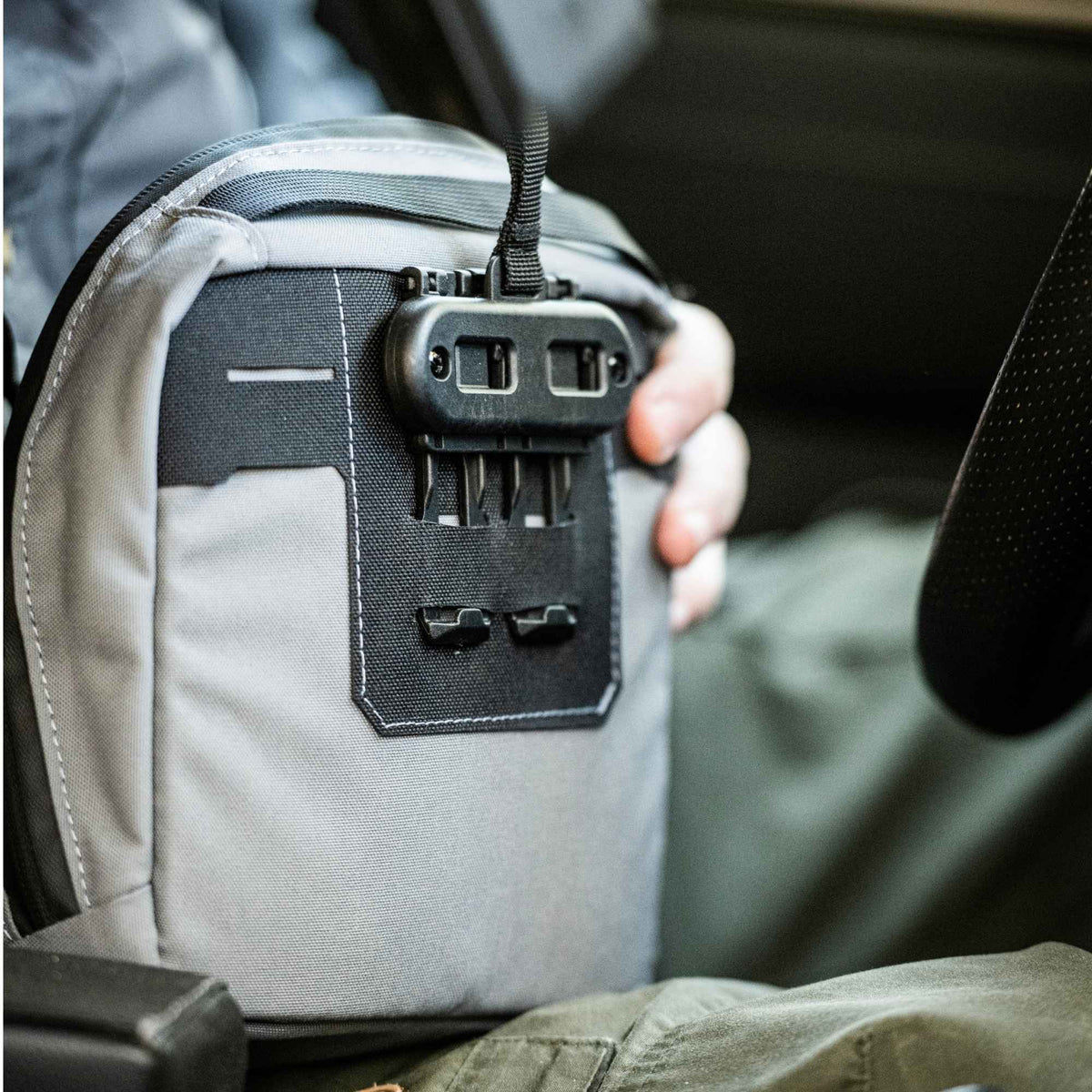 Man holding a grey Waypoint GP Pouch showing the back of it.