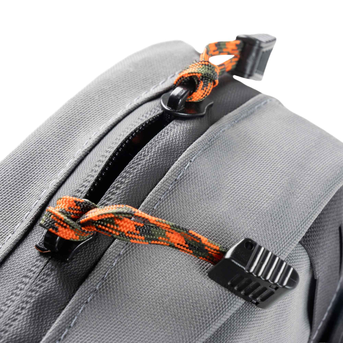 Close up shot of the zippers of the Waypoint GP Pouch, they have orange and black cords attached.