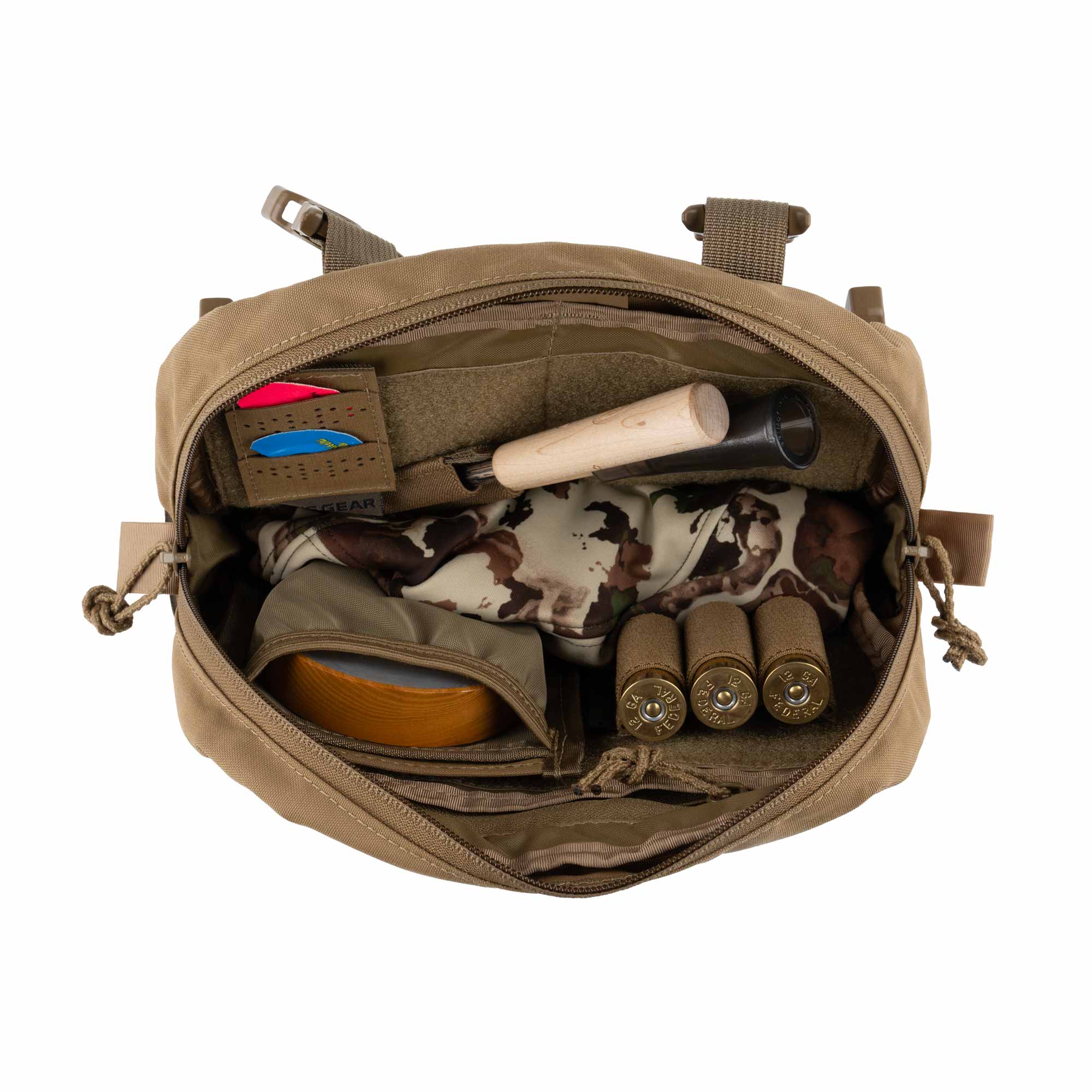 Open tan chest pouch with various items including ammunition and a camouflage-patterned cloth on a white background.