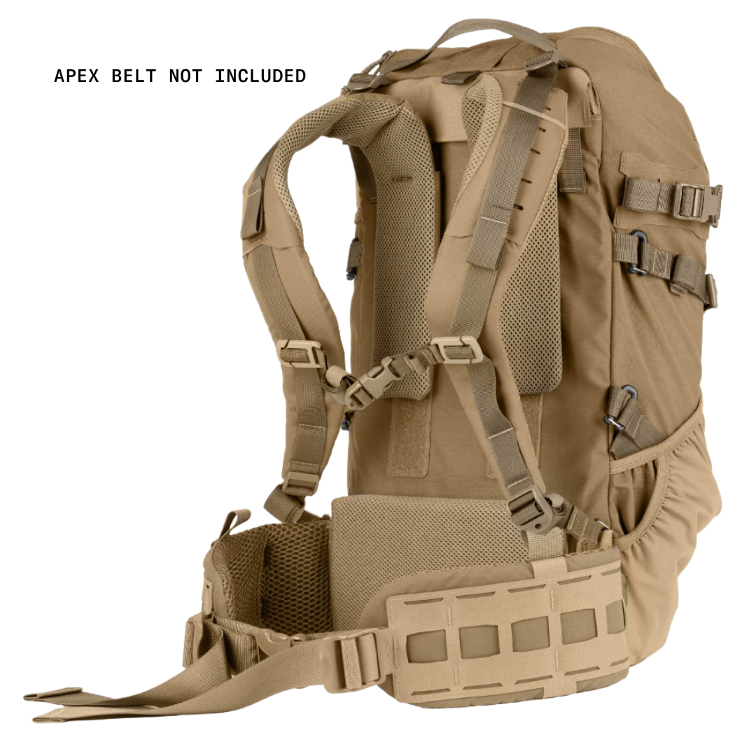 A tan tactical backpack shown from the back on a white background, with text in the upper left reading 'APEX BELT NOT INCLUDED'. The backpack features padded shoulder straps, mesh ventilation panels, side compression straps, and a lower webbing plate.