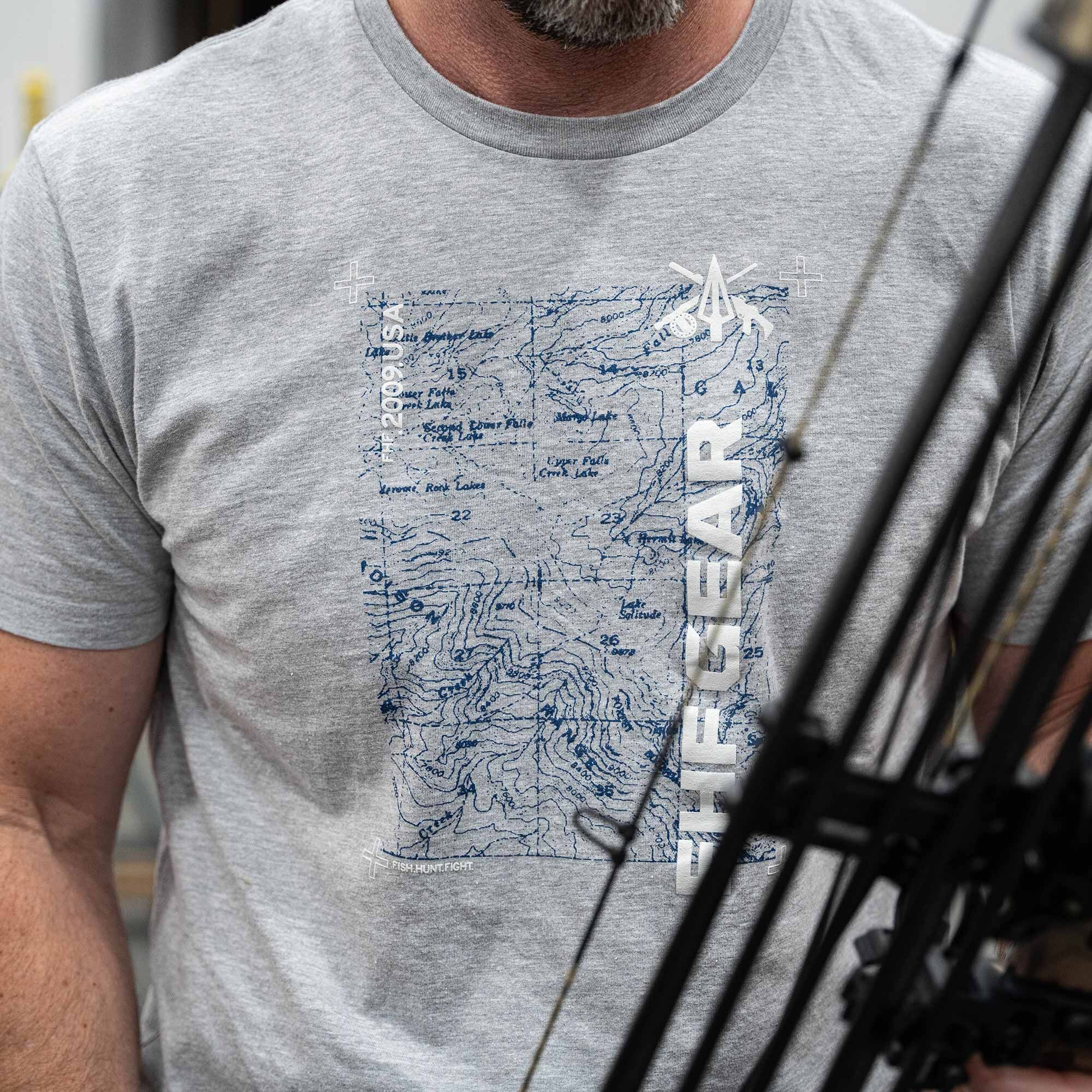 Gray T-shirt with blue map graphic and white 'THE GEAR' text. Bow partly visible.